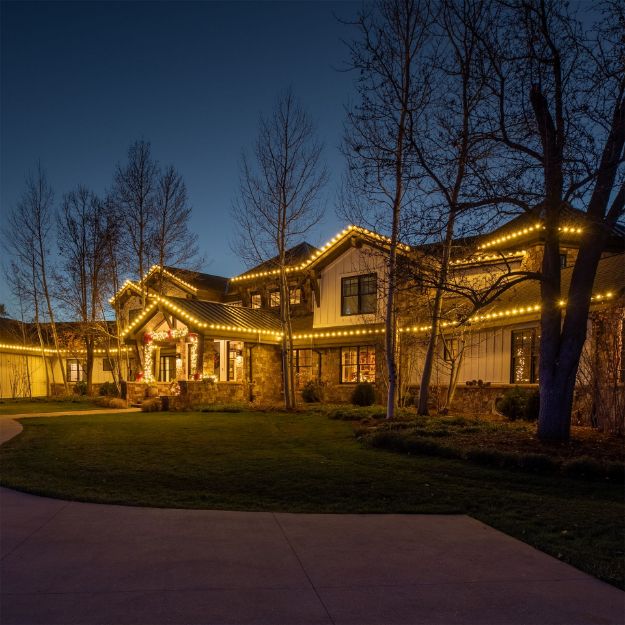 Warm white diamond faceted lights installed on a home at dusk