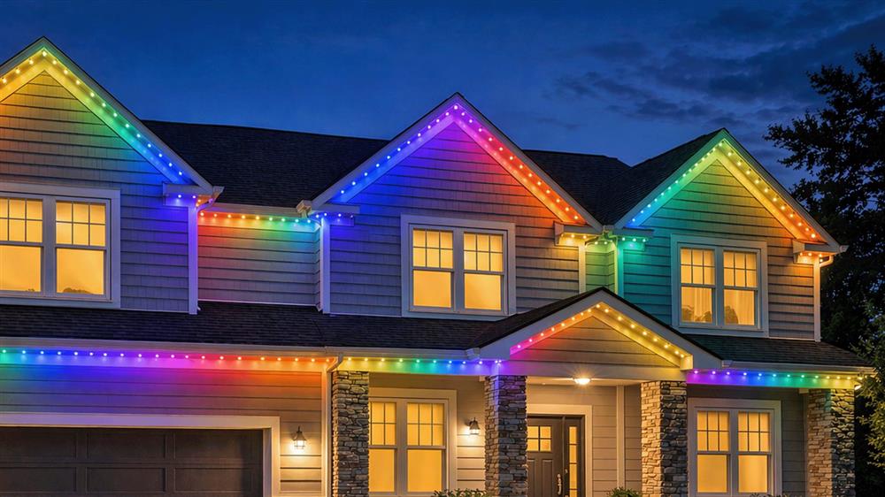 Two-story home at dusk with multicolored Twilight Trim LED dots outlining every roofline, gable and porch eave
